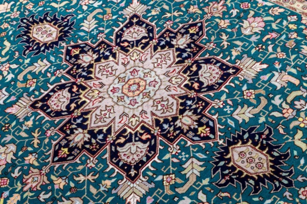 Hand-knotted Persian Heris design carpet from Tabriz, featuring teal green and black medallion pattern with silk-accented floral motifs – 2 x 1.5 meters.