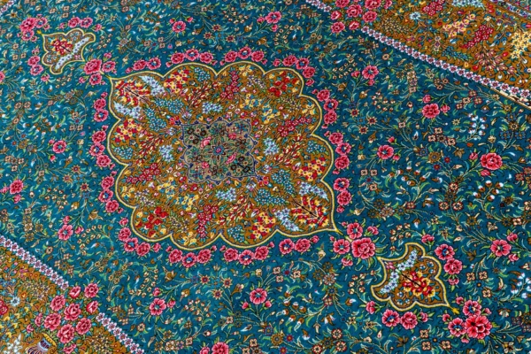 Qom silk carpet in full natural silk, hand-knotted in Iran with 80 Raj density. Features a turquoise floral design with central medallion.